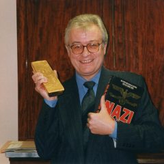 Several gold bullion bars sitting on a shelf inside a secure storage vault.