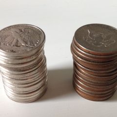 Several stacks of pure silver bullion coins sitting on a wooden surface.